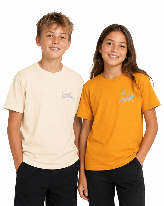 A boy and a girl standing side-by-side wearing matching short-sleeve t-shirts. The boy wears a cream-colored t-shirt and the girl wears a mustard yellow t-shirt, both featuring a small light gray ant logo on the left chest.